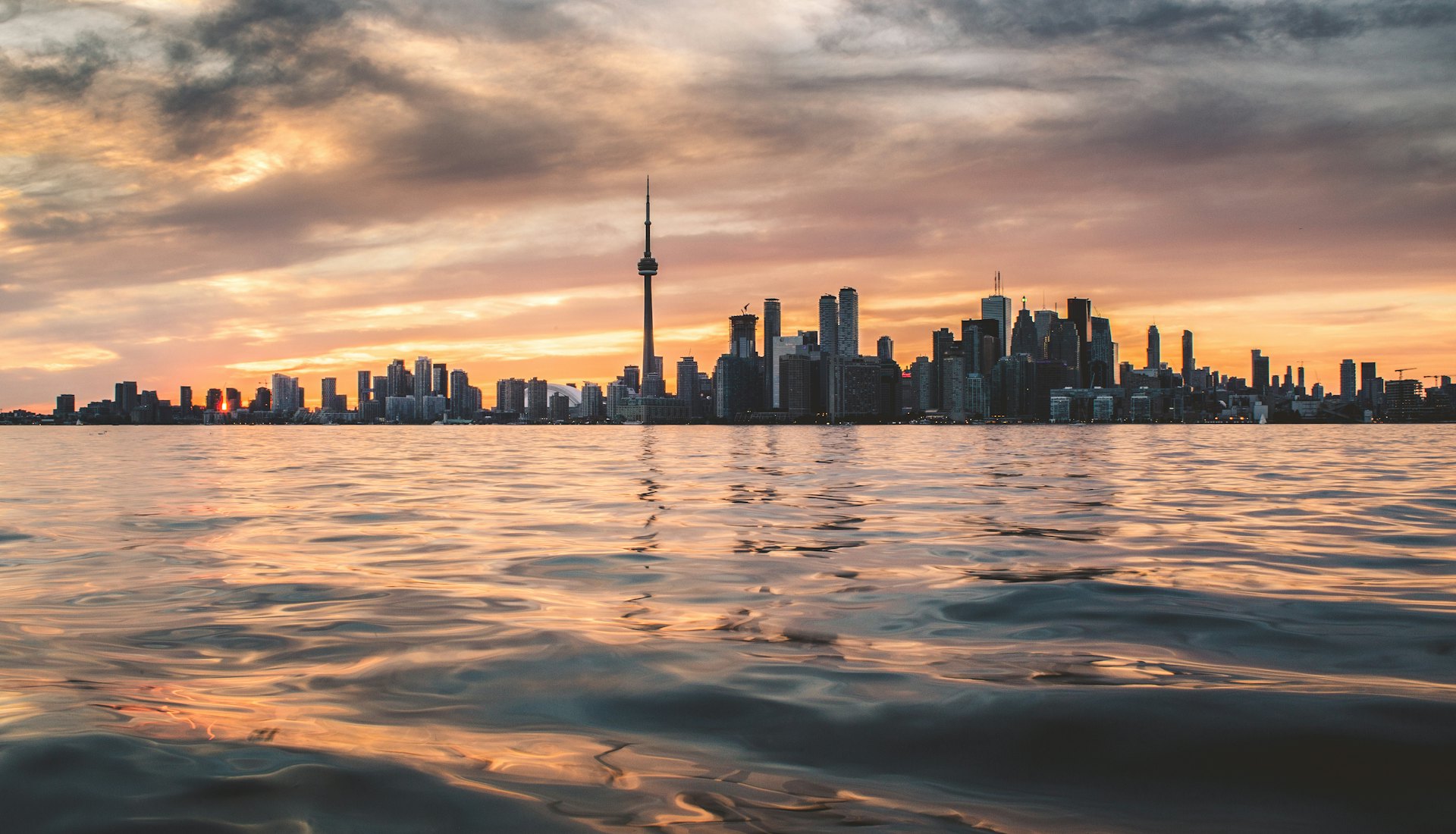 Toronto city skyline at golden hour, viewed across Lake Ontario.
